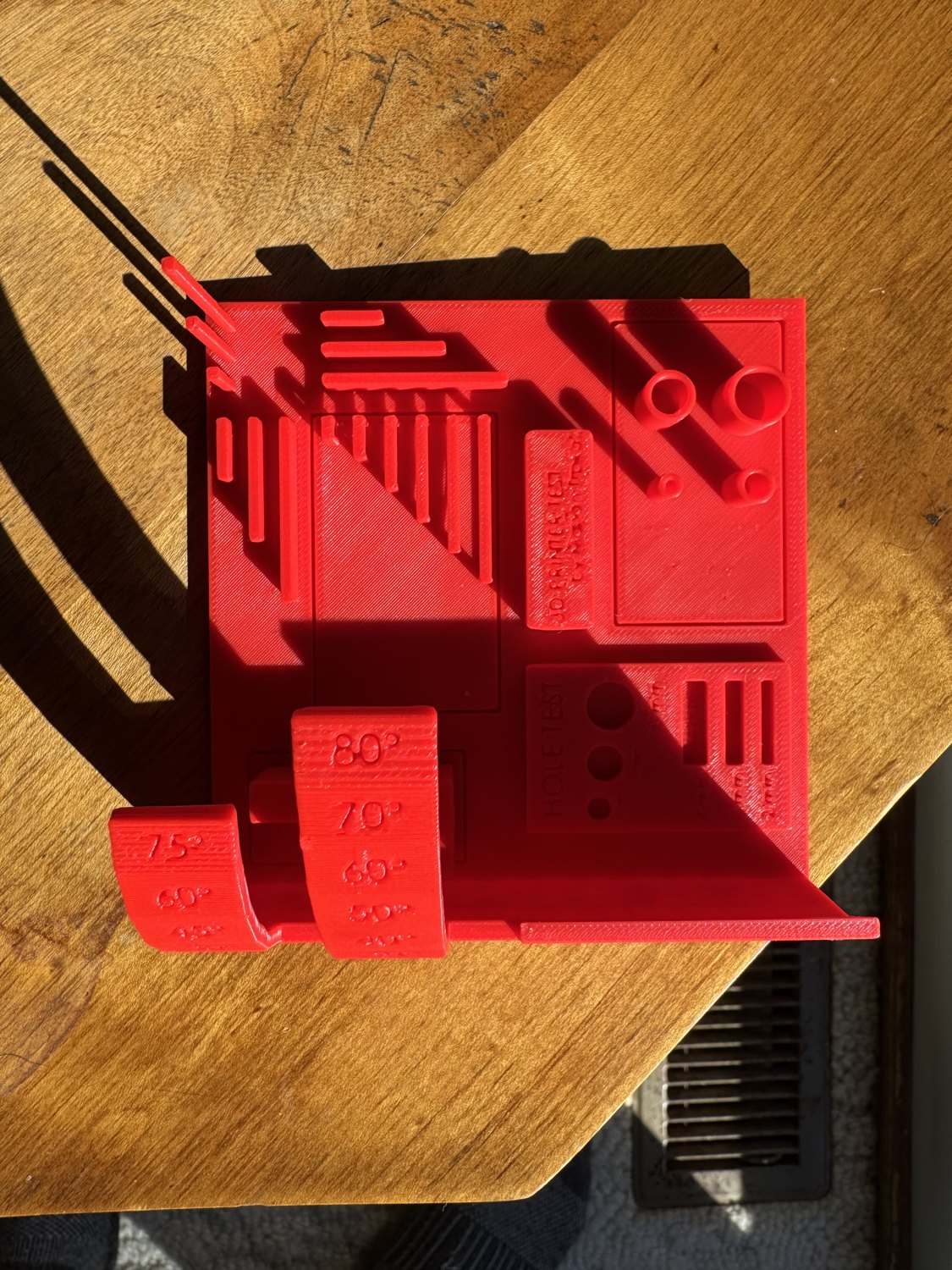 Top view of the red printer test showing thin walls, bridges, and round openings